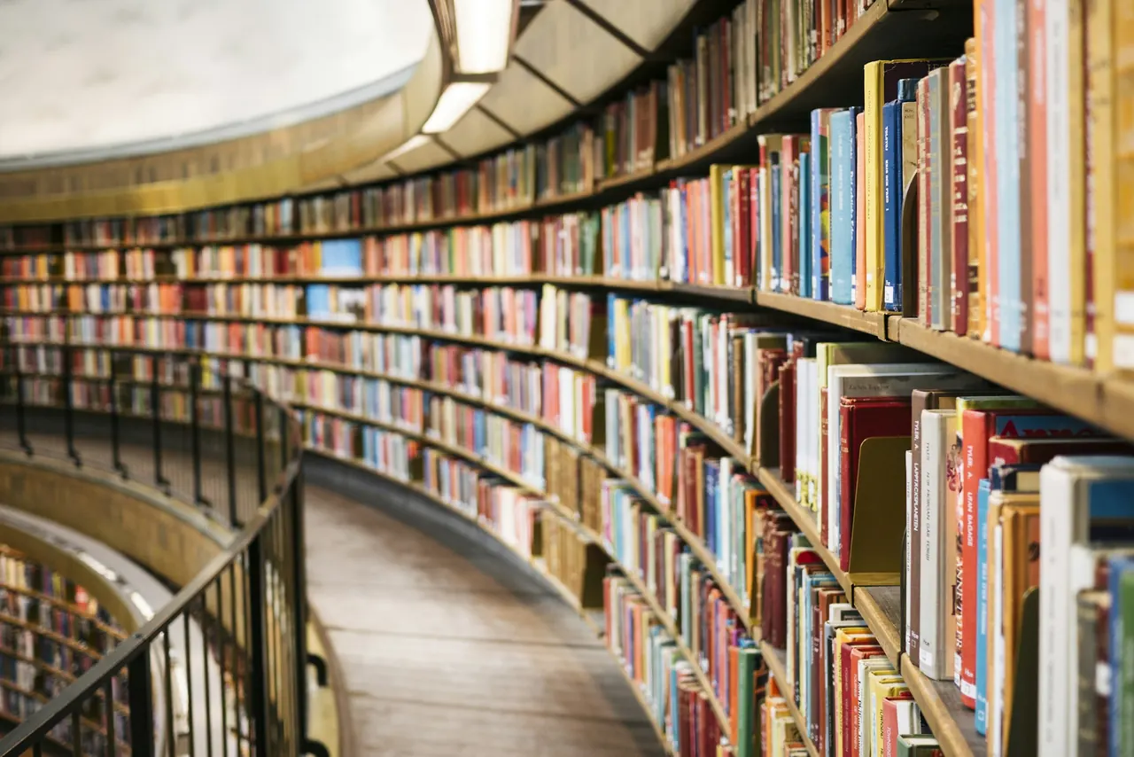 Books following the curved wooden shelves of Stockholm City Library
