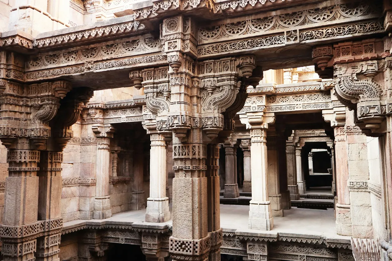 Intricately carved sandstone columns at Adalaj Stepwell in Gujarat